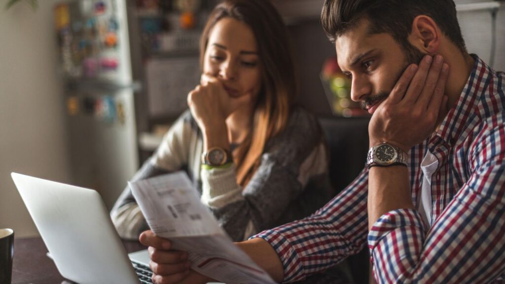 couple looking at bills and laptop