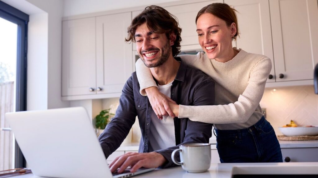 Young couple reviewing finances on a laptop, representing how credit unions can attract younger members