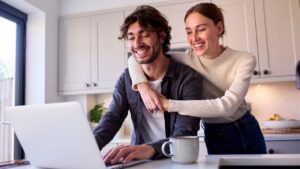 Young couple reviewing finances on a laptop, representing how credit unions can attract younger members
